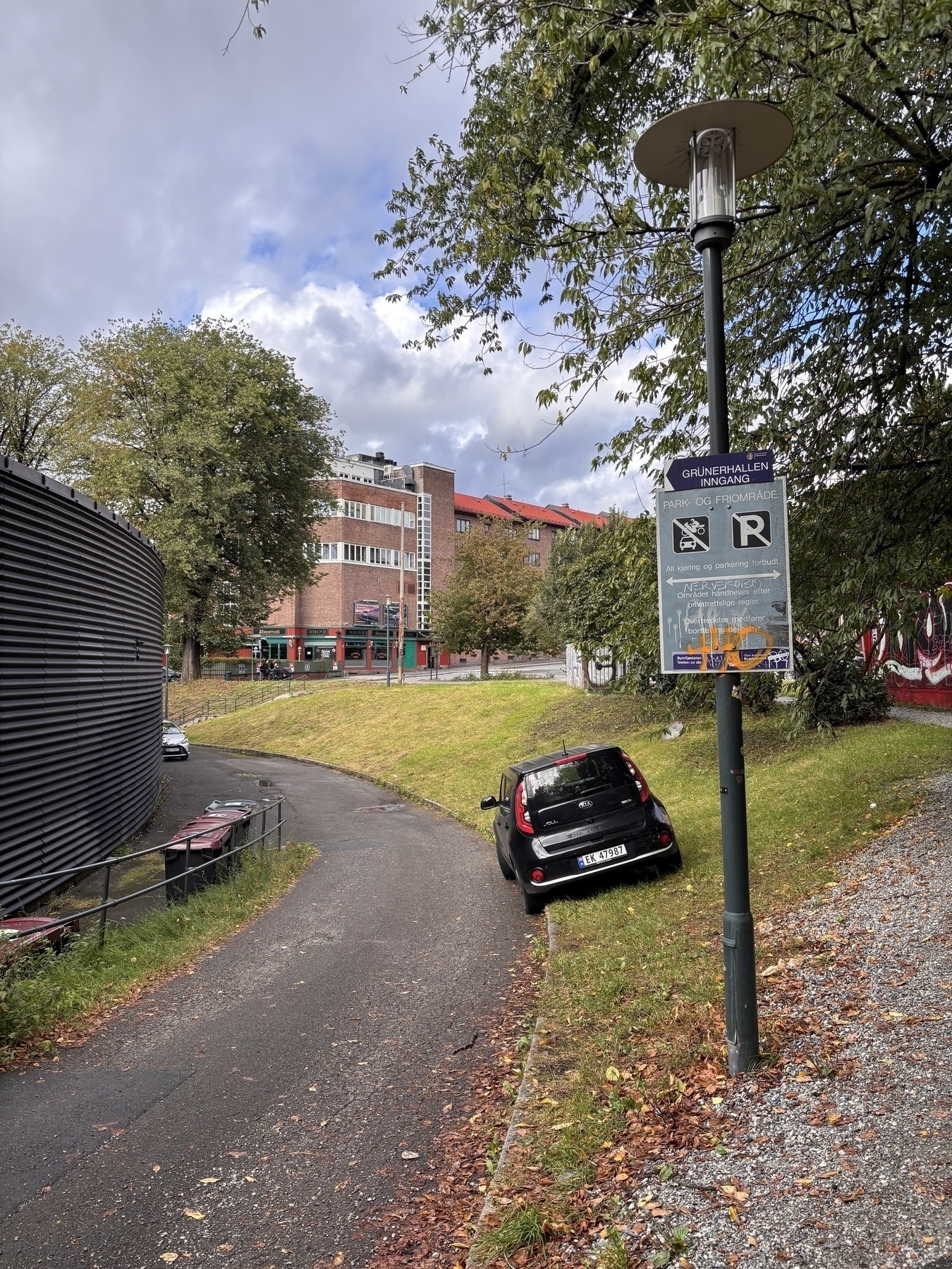 Car parked in park. Sign says not to.