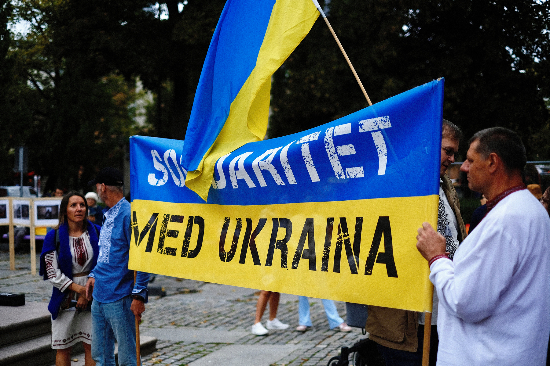 En gruppe mennesker holder et blått og gult banner med teksten Solidaritet med Ukraina ved en utendørs samling.&10;&10;Oslo, 24.aug. 2024