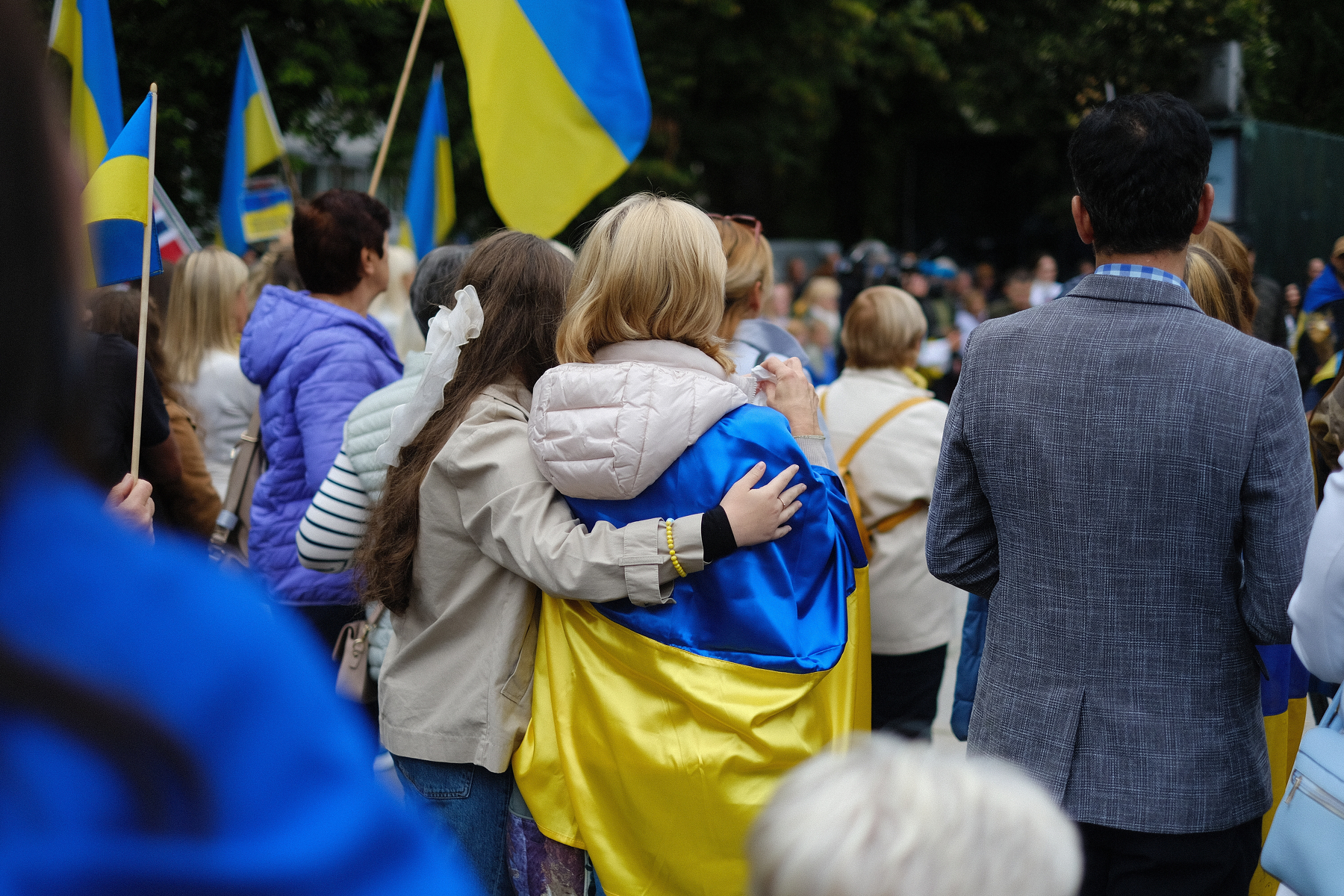 En gruppe mennesker med ukrainske flagg samles, hvor noen av dem holder rundt hverandre.&10;&10;Oslo, 23.08.24